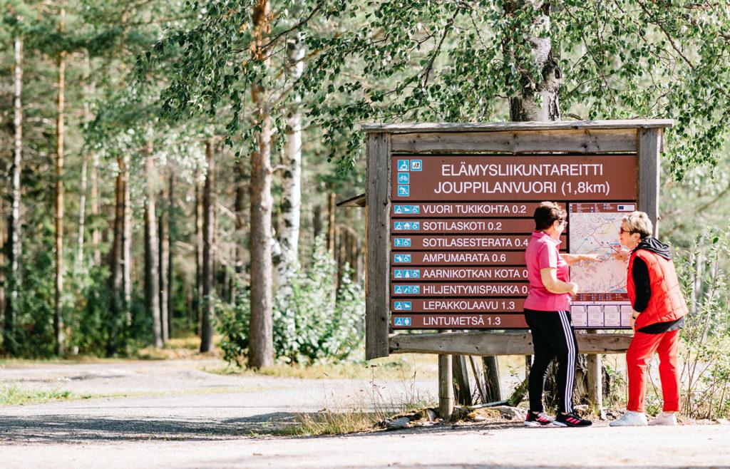 Kaksi ihmistä lähdössä Jouppilanvuoren luontoreitille