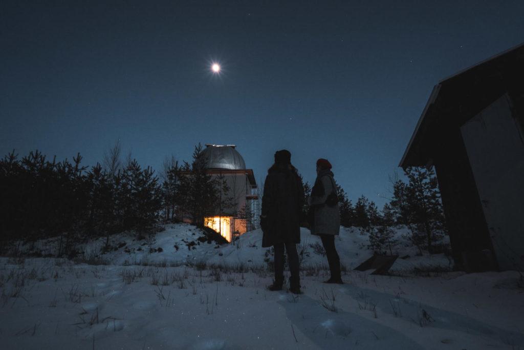 Naiset katsovat Ursa-tähtitornia pimeällä säällä