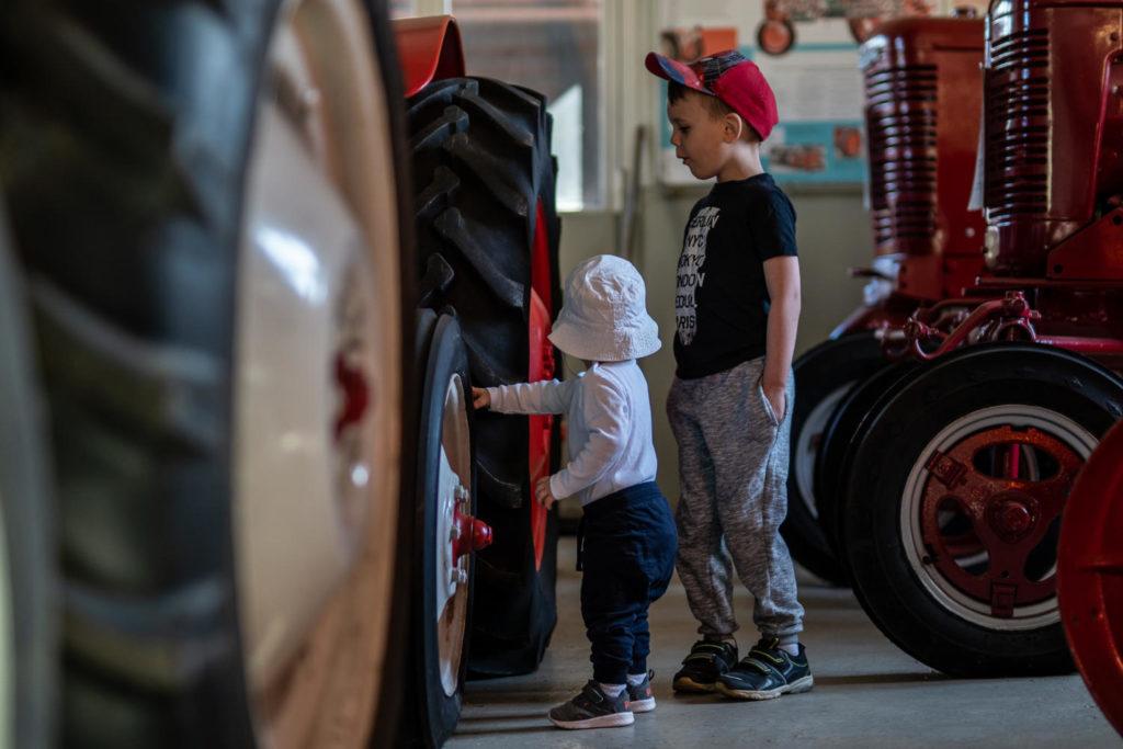 Kaksi lasta ihastelee traktoria traktorimuseolla