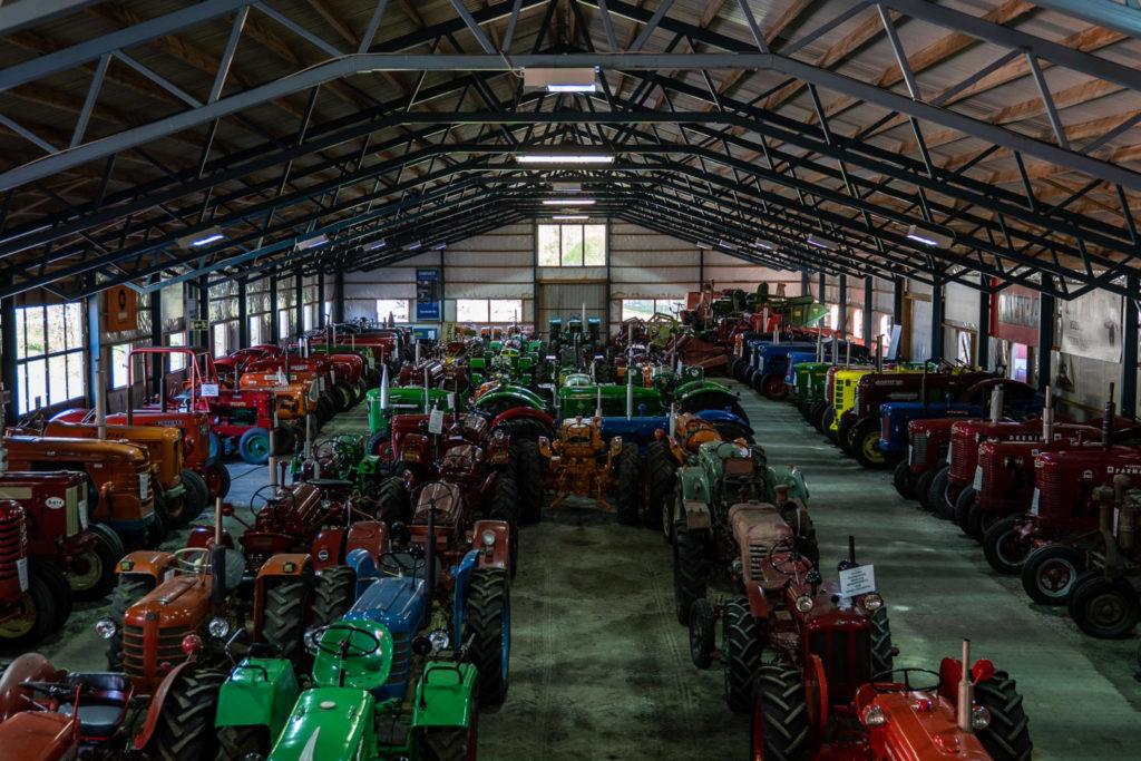Traktorimuseon hallissa useita erilaisia traktoreita rivissä