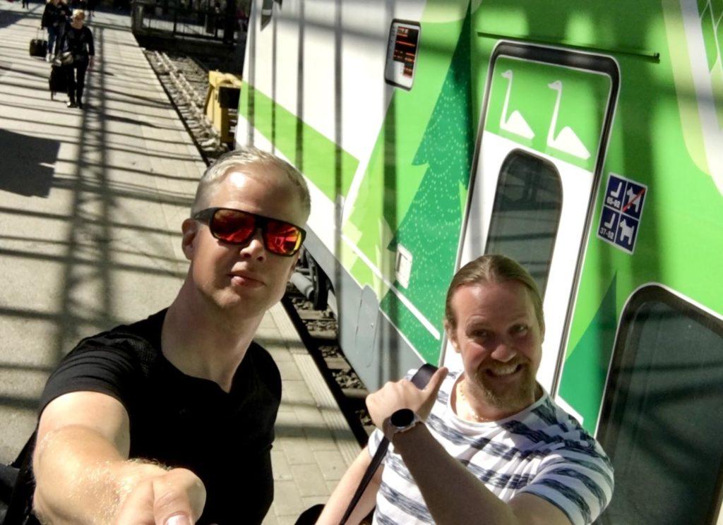 Miehet ottavat selfien junan edessä Seinäjoen juna-asemalla.