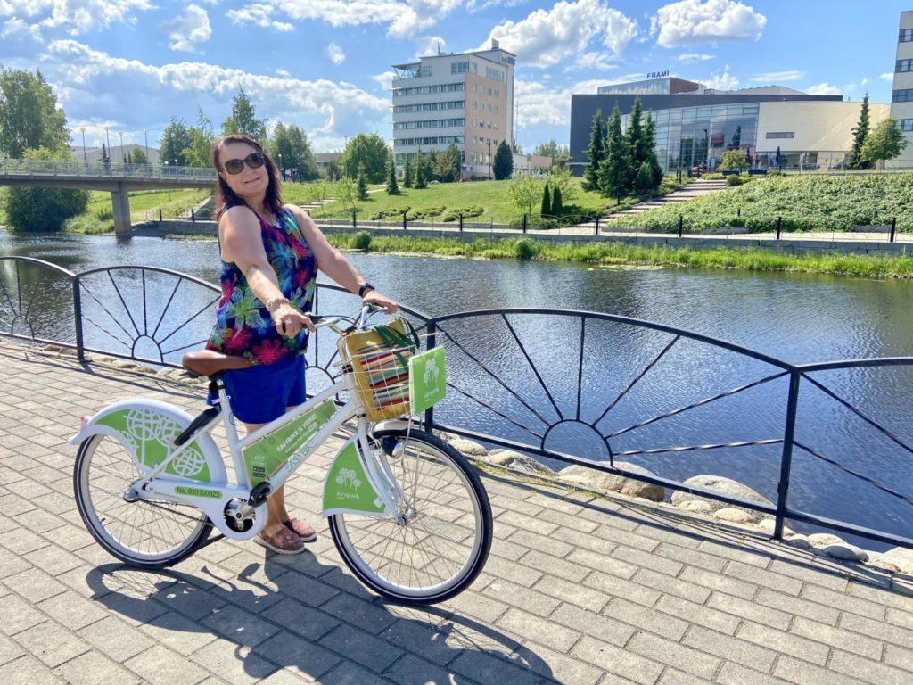 nainen pyöräilee Seinäjoen kampusrannassa poseeraten