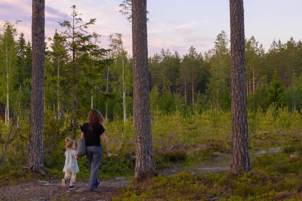 Nainen ja lapsi kävelemässä metsäisellä lenkkipolulla
