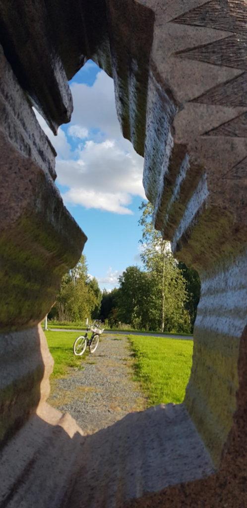 Suomi-patsas Lukion pihassa, jonka läpi voi nähdä