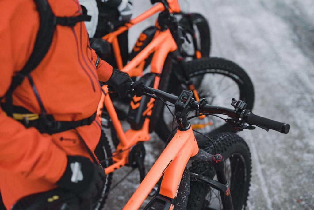 Oranssit maastopyörät pyöräilijöiden käsissä