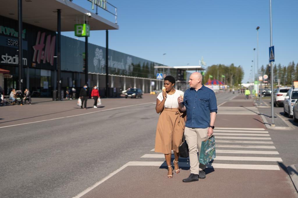 Pariskunta kävelee Ideapark Seinäjoen parkkipaikalla jäätelöt ja ostokset kädessä