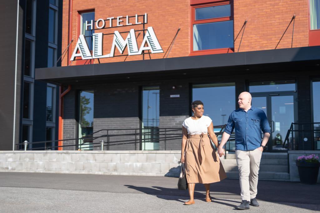 Pariskunta kävelemässä käsi kädessä pois Hotelli Almalta.