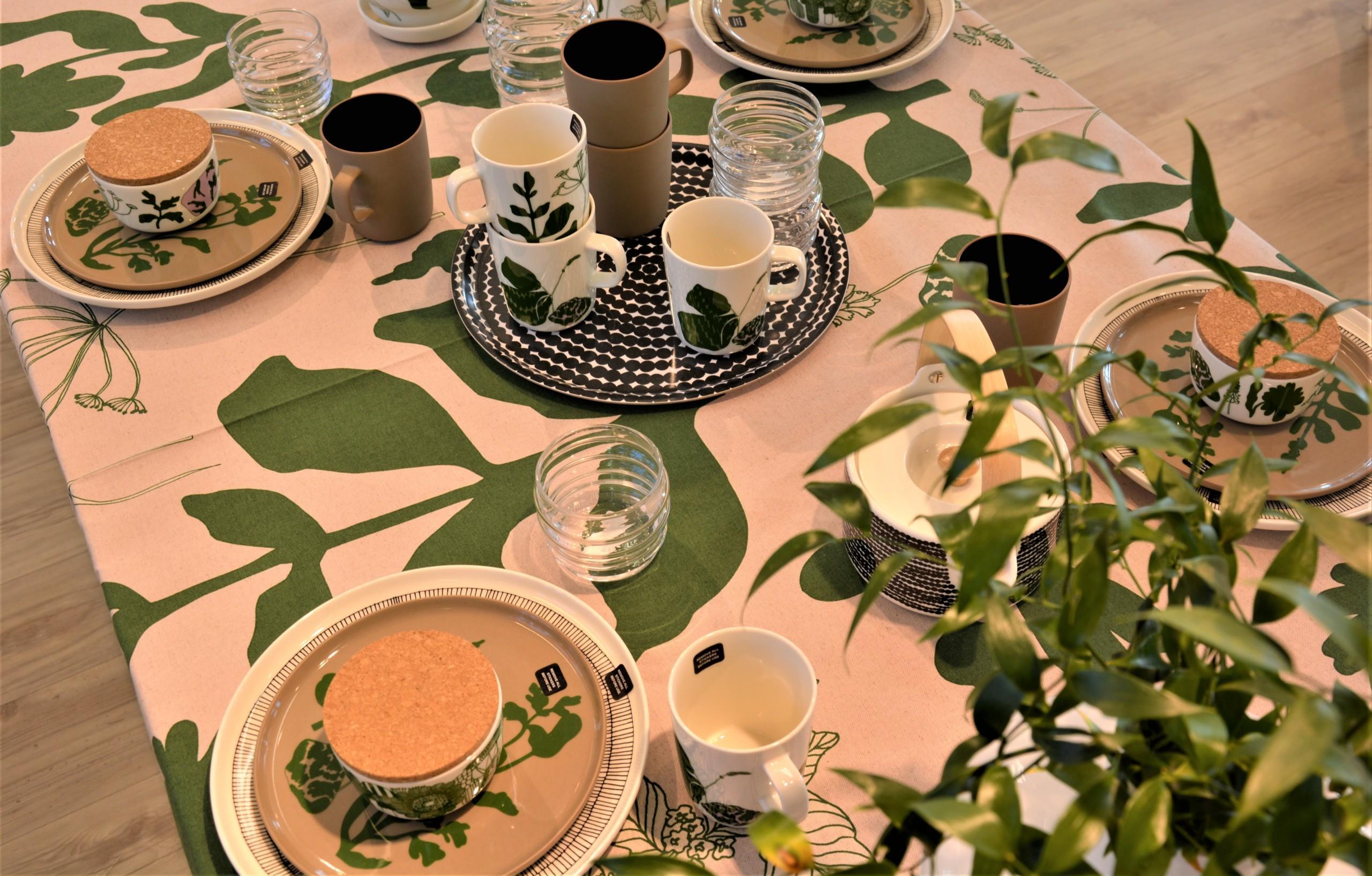 Marimekon lautaset, liina ja muut tuotteet pöydällä