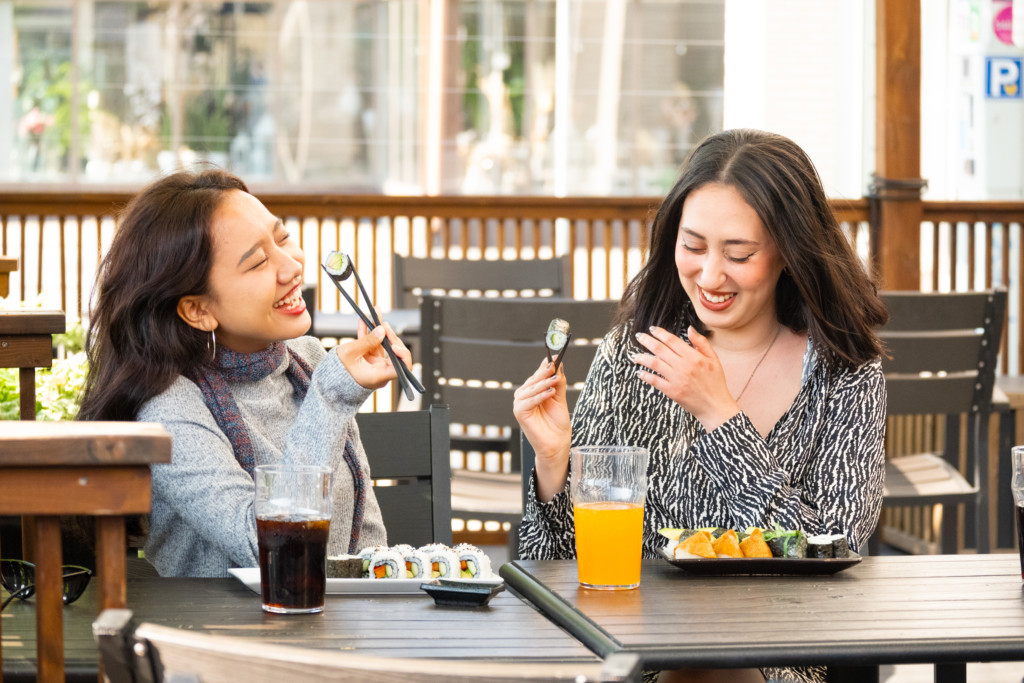 Kaksi naista syömässä sushia Ravintola Jukun terassilla