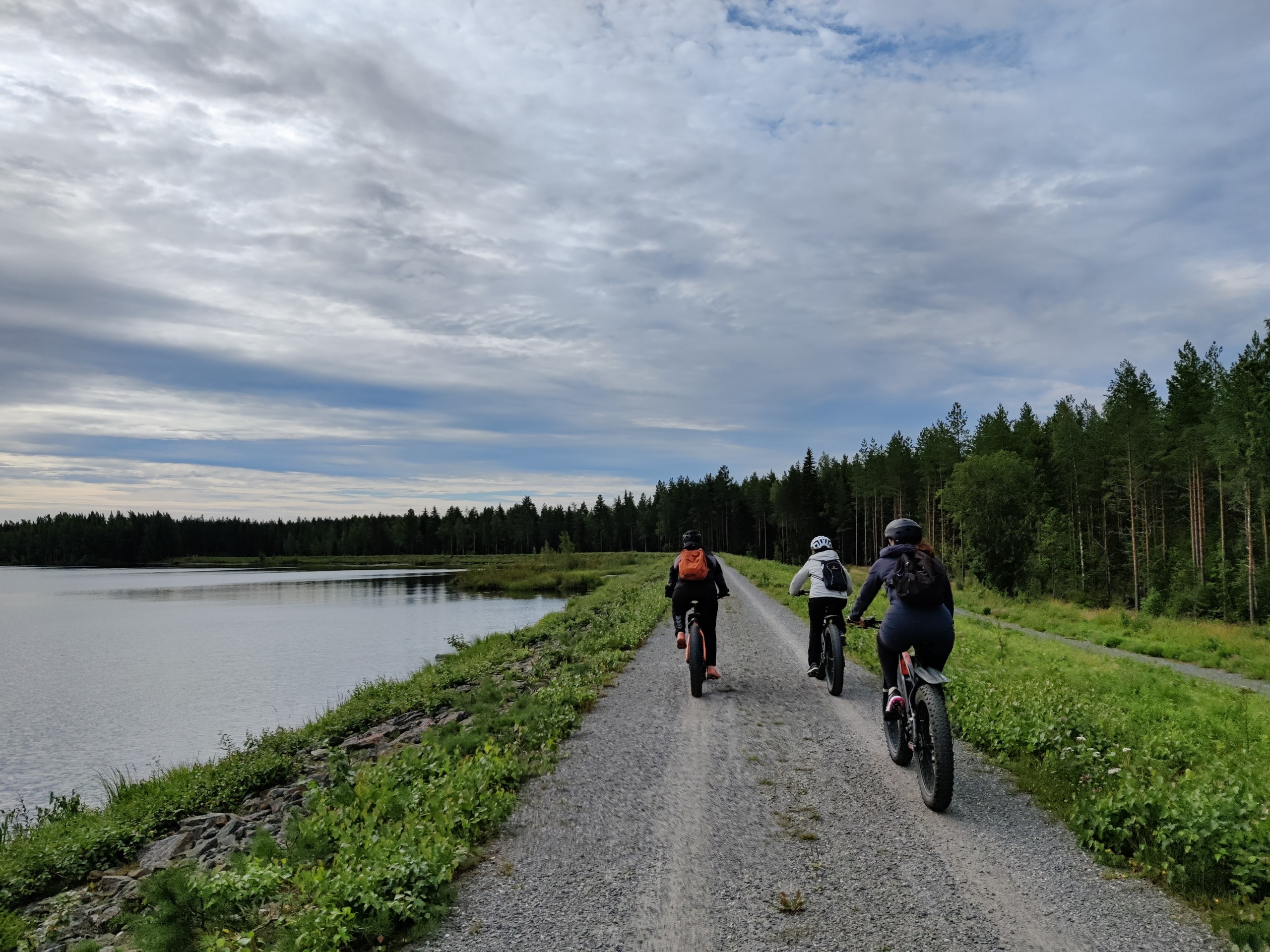 Pyöräilijät polkevat sähköisillä fatbike pyörillä Seinäjoen Kyrkösjärven viereistä pyöräreittiä.